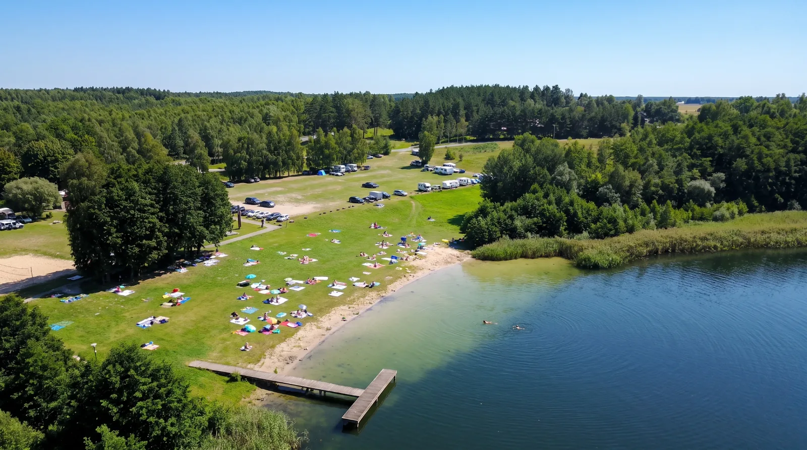 Piaszczysta plaża nad Jeziorem Stelchno z pomostem i kąpielowiskami